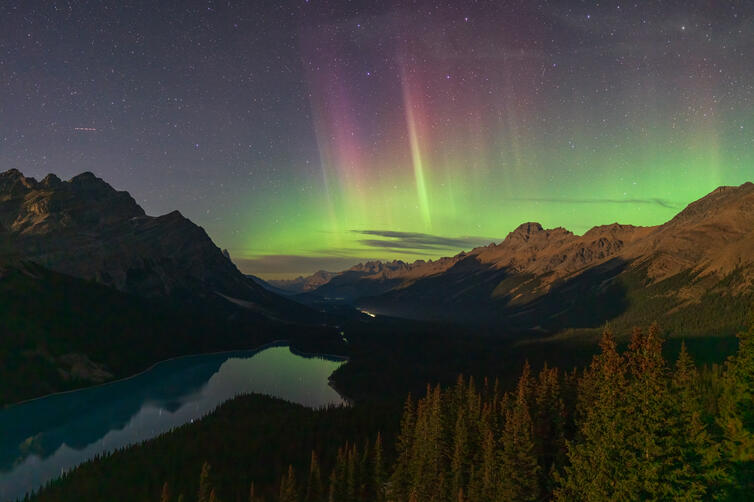 Aurora makes an appearance over Banff National Park in Alberta, Canada, hovering over the milky waters of Peyto Lake